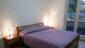 Une chambre à coucher avec un lit, des tables de chevet et une fenêtre donnant sur l’extérieur.