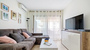 Una sala de estar moderna con un sofá modular, un televisor de pantalla plana y una mesa de centro blanca.