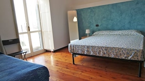A bedroom with a bed, a chair, a nightstand, a lamp, and a large mirror. - Villa Sant'Antonio (Ascea)
