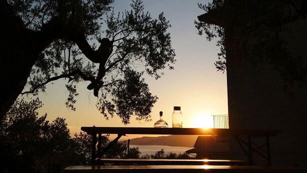 A sunset view from a balcony with a table and two bottles. - Villa Sant'Antonio (Ascea)