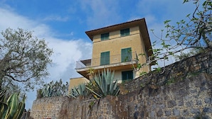 A two-story building with a stone wall and a balcony. - Villa Sant'Antonio (Ascea)