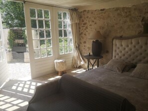 A bedroom with a bed, a lamp, and a view through a window. - Chambres d'Hôtes Le Mouton (Blaison-Saint-Sulpice)