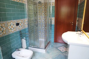 Un baño con ducha, lavamanos e inodoro.