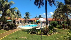 A pool area with lounge chairs, umbrellas, and a water slide. - Hotel Praia Do Conde (Conde)