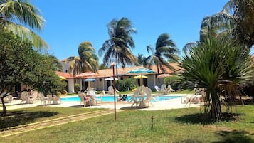 Piscine couverte, piscine extérieure, parasols de plage, chaises longues