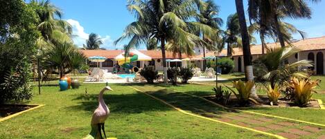 Una piscina techada, una piscina al aire libre, sombrillas