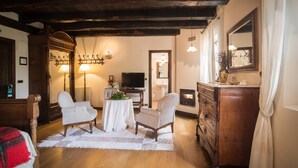 A cozy room with wooden furniture, a fireplace, a television, and a mirror. - Caserio Iruaritz (Amurrio)