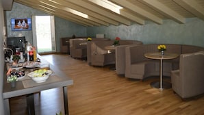 A modern interior with a wooden ceiling, a bar area with seating, and a dining table with a bowl of fruit. - B&B Jolie Center (Pescara)