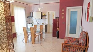 A compact living space with a dining area, kitchen, and a small seating area. - Casa Eleatica (Ascea)