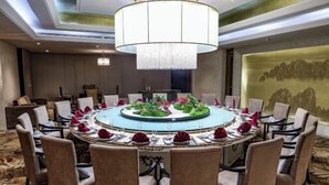 A conference room with a round table, chairs, and a chandelier. - Huifeng Hotel (Shuyang)