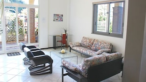 A room with a sofa, chairs, a glass coffee table, and a window. - Cilento Loft (Ascea)