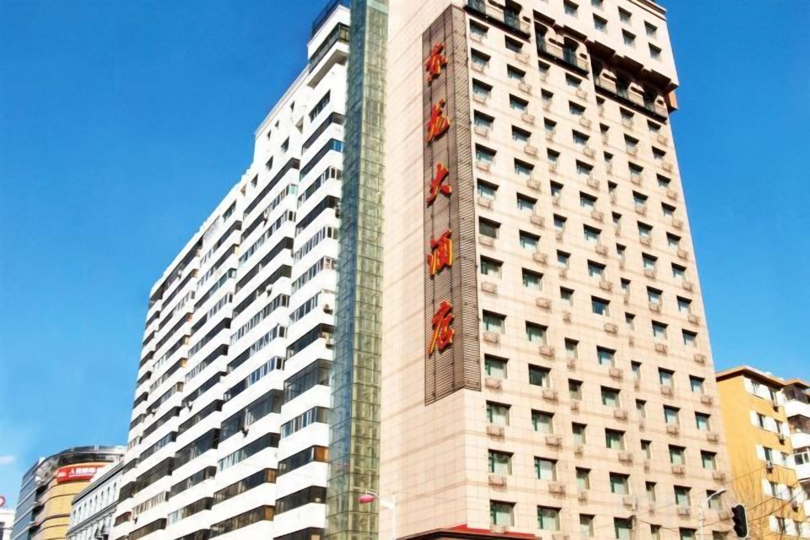 Un edificio de varios pisos con un letrero vertical destacado en la fachada.