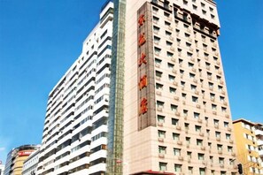 Un edificio a più piani con un cartello verticale ben visibile.