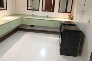A bathroom with two sinks, a mirror above each sink, and a black trash bin. - Donglong Hotel (Harbin)