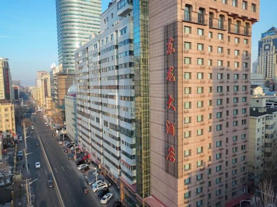 A high-rise building with multiple floors, a prominent entrance, and a clear view of the street below.
