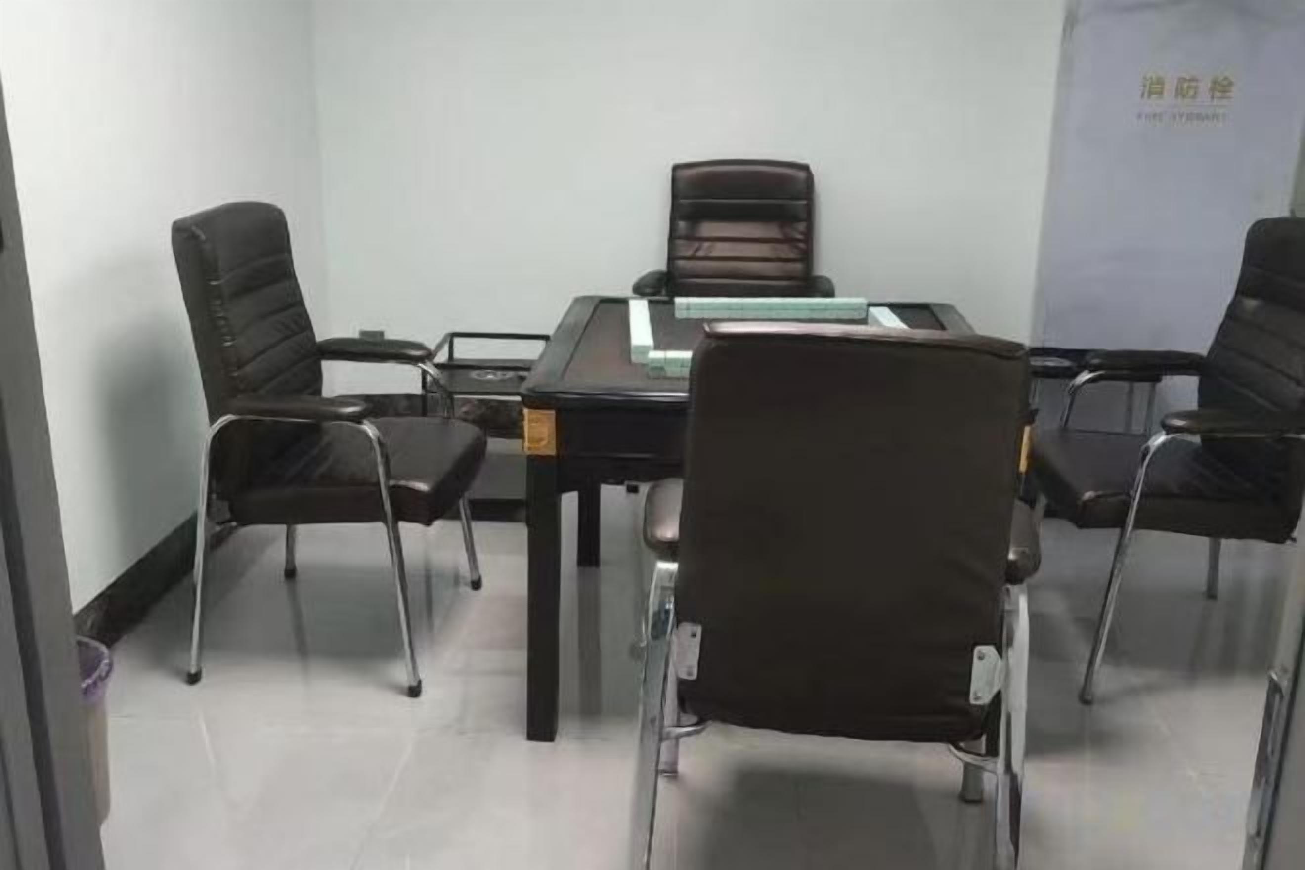 Une salle de conférence avec une table rectangulaire, quatre chaises noires et un tableau blanc.
