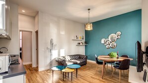 Une cuisine moderne avec des meubles blancs, un four à micro-ondes encastré et une machine à café.