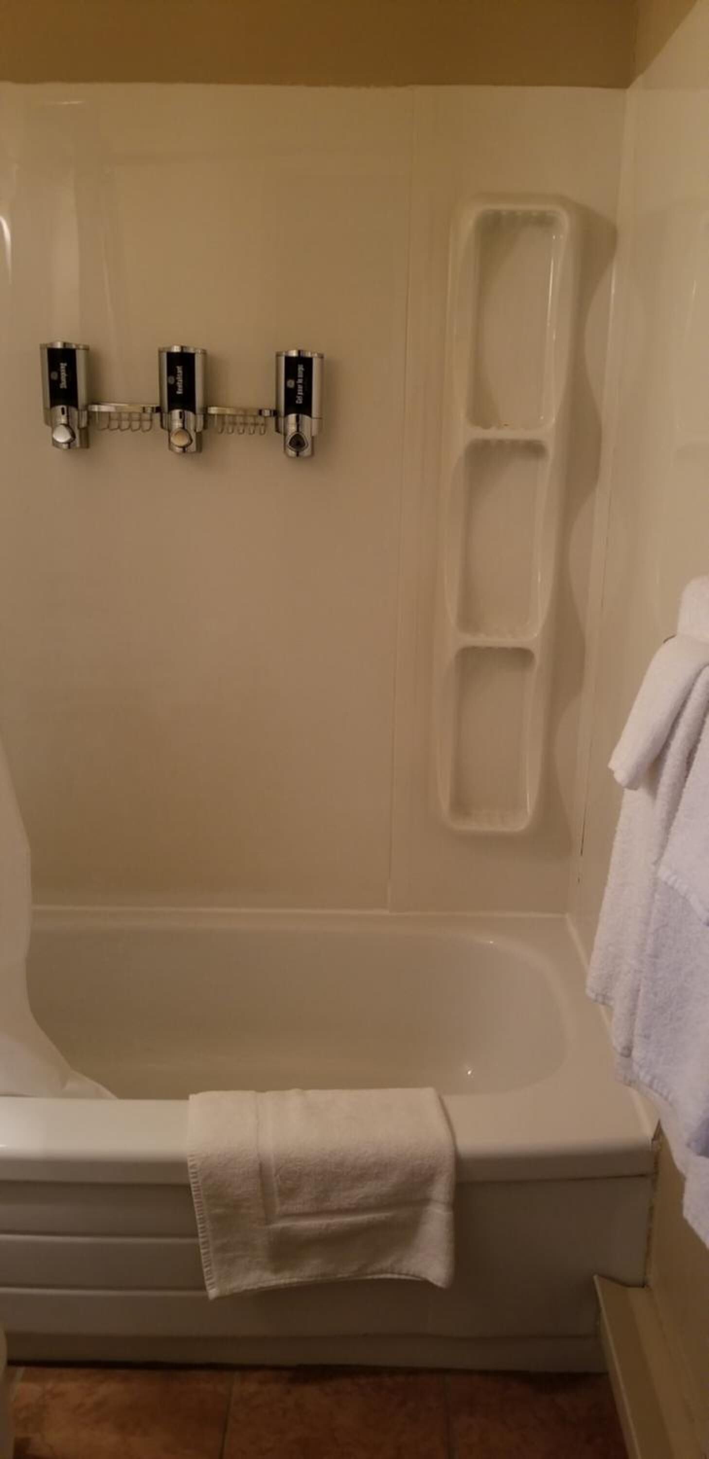 Un baño con bañera, ducha y barra para toallas.
