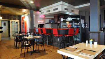 A restaurant with red bar stools, a bar area, and a seating area with tables and chairs.