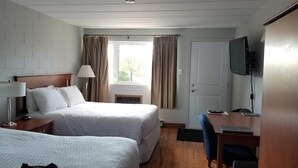A hotel room with two beds, a desk, a chair, a TV, and a window with curtains. - Auberge Happy Logis (Lac-Etchemin)