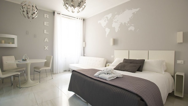A modern hotel room with a large bed, a desk, and a chair. There is a world map on the wall and a 'RELAX' sign. - Ca dei Nobili (Genoa)