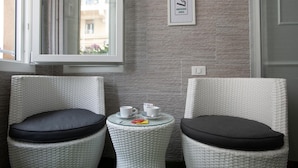 A room with two wicker chairs, each with a black cushion, and a small table with a cup and saucer. - Ca dei Nobili (Genoa)