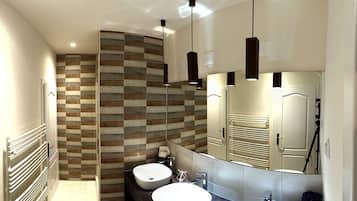Un baño moderno con dos lavamanos, un espejo grande y un diseño de pared a cuadros.