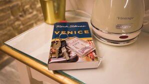 A book titled "Venice" by Rick Steves, a set of keys, and a vintage-style kettle on a table. - Cà Patron (Venice)