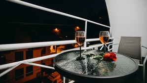 A round table with two wine glasses and a rose on a balcony railing. - Art Boutique Central (Tirgu Jiu)