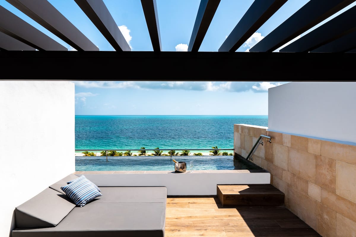 A modern outdoor seating area with a view of the ocean.
