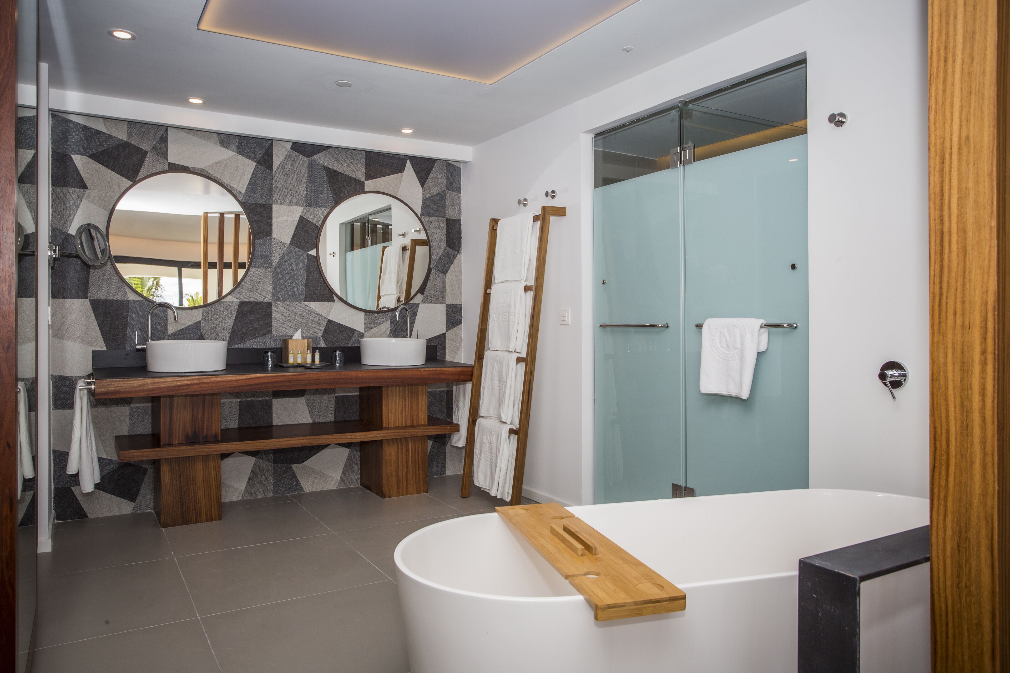 Une salle de bain moderne avec une baignoire sur pieds, un meuble-lavabo avec un évier et un miroir, et un espace douche.