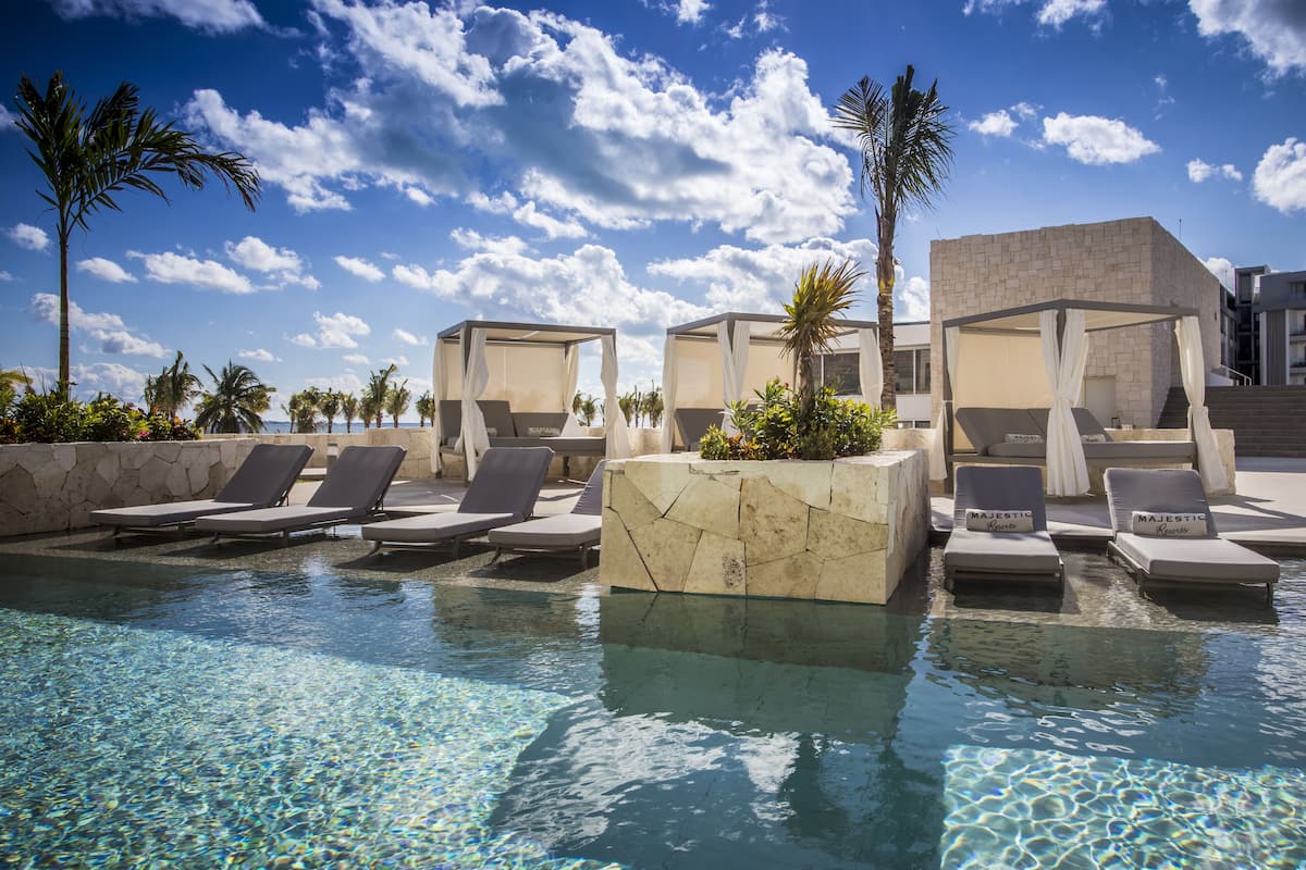 A pool area with lounge chairs and a stone structure.