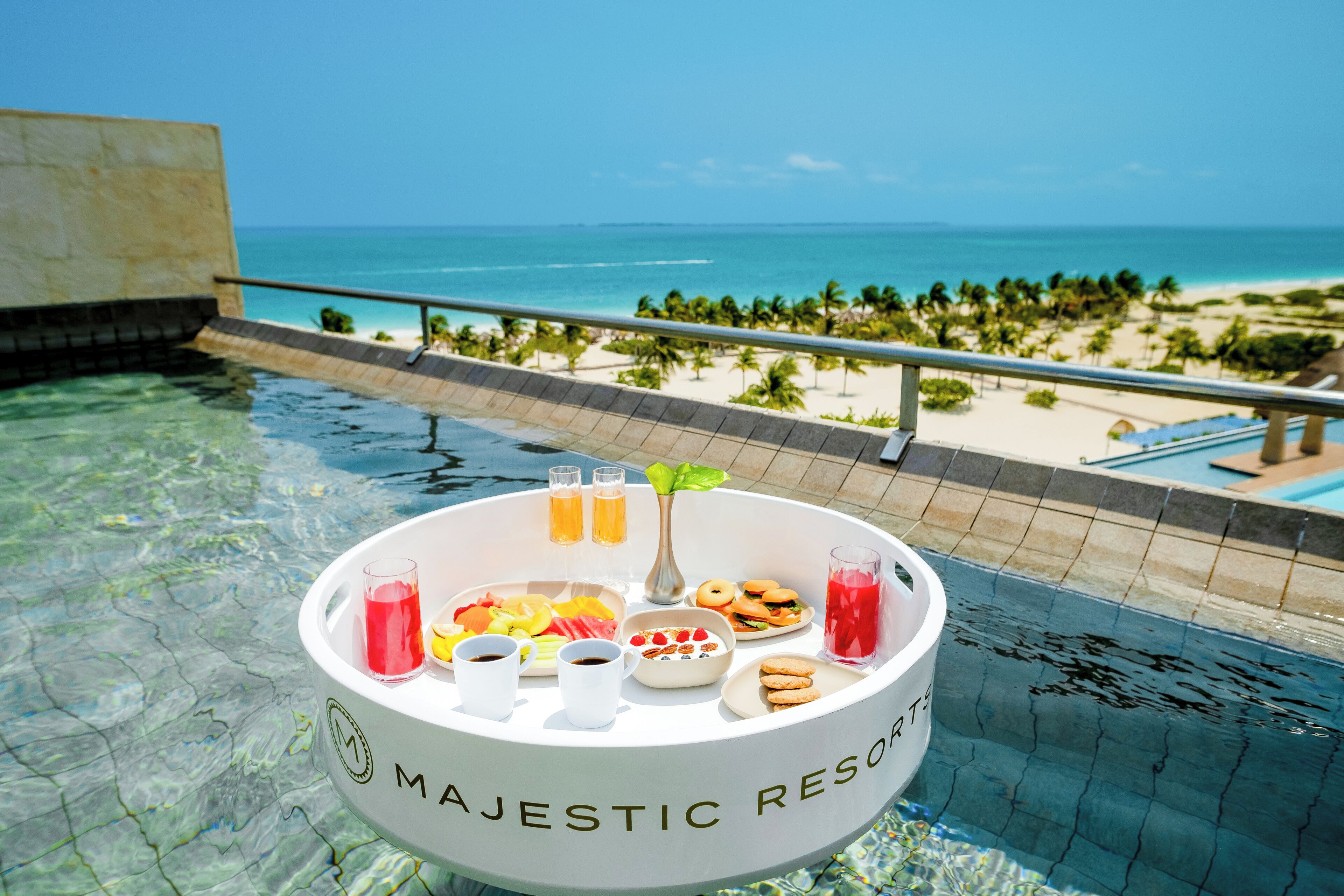 A poolside setting at Majestic Resort with a clear view of the beach and ocean.