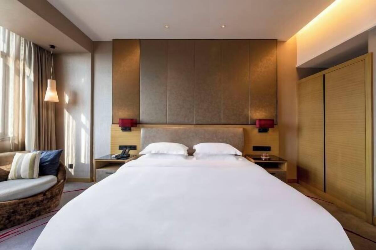 Ein Hotelzimmer mit einem großen Bett, Nachttischen, einer Sitzecke und einem Kleiderschrank.