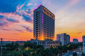 A high-rise hotel with multiple floors, a prominent entrance, and a view of the surrounding cityscape. - 3b Hotel (Yuyao Shengshan) (Yuyao)