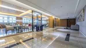 A spacious lobby with a polished marble floor, glass partitions, and a reception desk. - 3b Hotel (Yuyao Shengshan) (Yuyao)