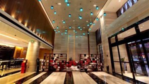 A spacious lobby with a high ceiling, multiple seating areas, and a modern design. - 3b Hotel (Yuyao Shengshan) (Yuyao)