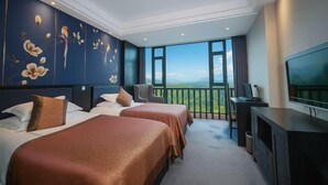 A hotel room with two beds, a TV, and a balcony with a city view. - Victoria Royal Hotel (Shangrao)