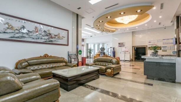 A modern lobby with leather sofas, a reception desk, and a large framed artwork on the wall. - Hongyang Hotel (Chongqing)