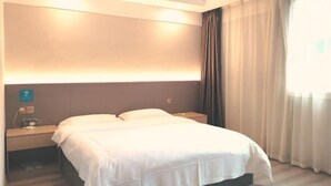 A hotel room with a bed, bedside table, and a window with curtains. - Hongyang Hotel (Chongqing)
