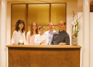 A reception desk with a group of people standing behind it.