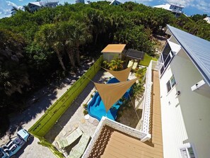 A residential property with a swimming pool, a fenced yard, and a house with a white exterior.