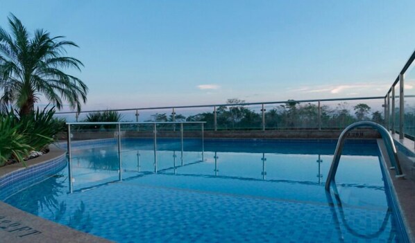 Una piscina al aire libre, tumbonas