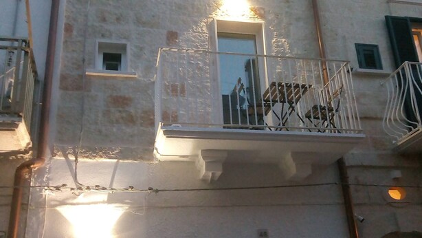 A building with a balcony, a window, and a door. - Romì (Polignano a Mare)