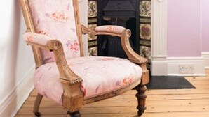 A wooden chair with floral upholstery in a room with a white fireplace and a pink wall. - Hexham Town Bed and Breakfast (Hexham)