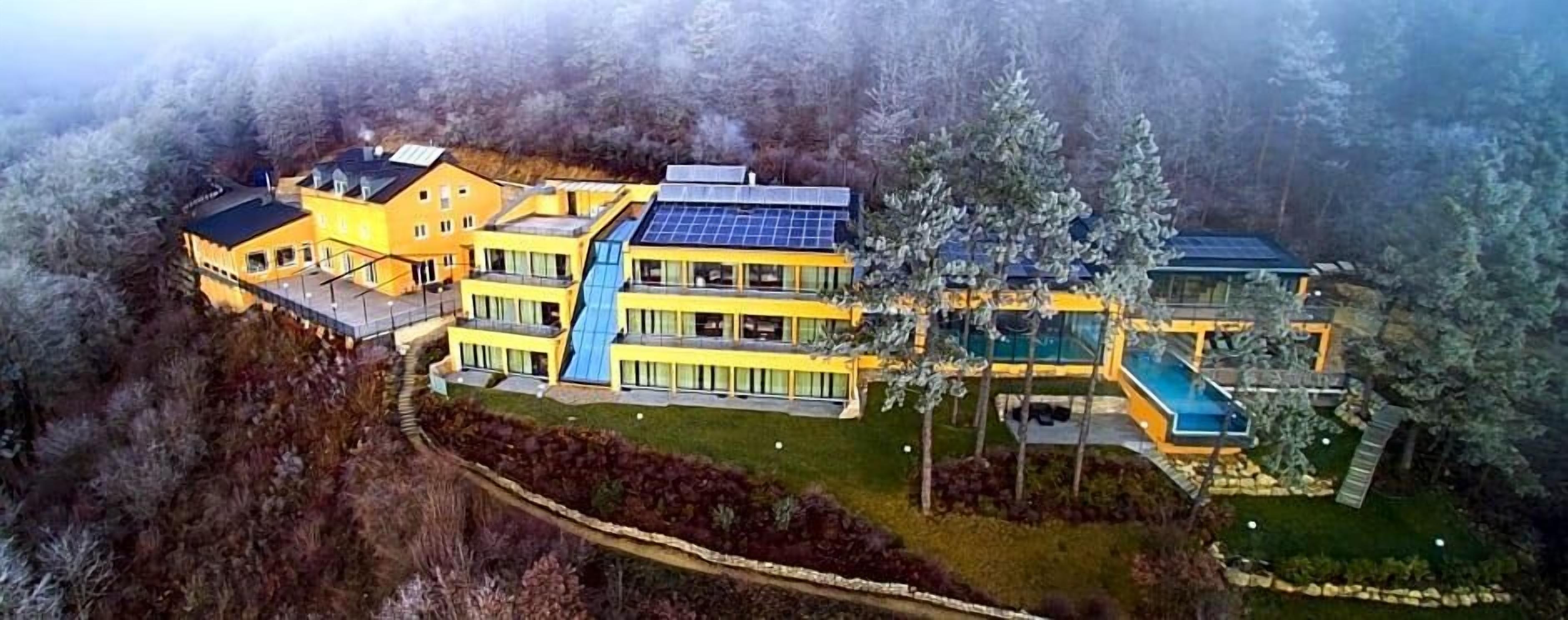 Ein mehrstöckiges Gebäude mit Swimmingpool und Solaranlage.
