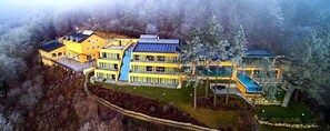 Un edificio de varios pisos con piscina y paneles solares.