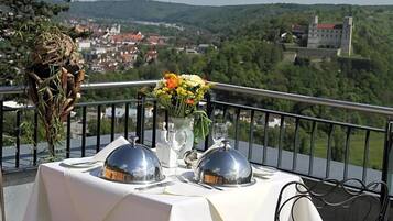 Ein Esstisch mit Blick auf eine Stadt und Hügel in der Ferne.