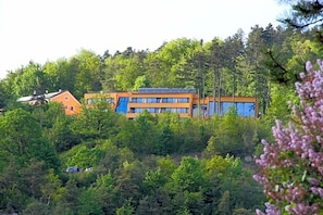 Un bâtiment entouré d’une forêt dense, dont l’extérieur est clairement visible.