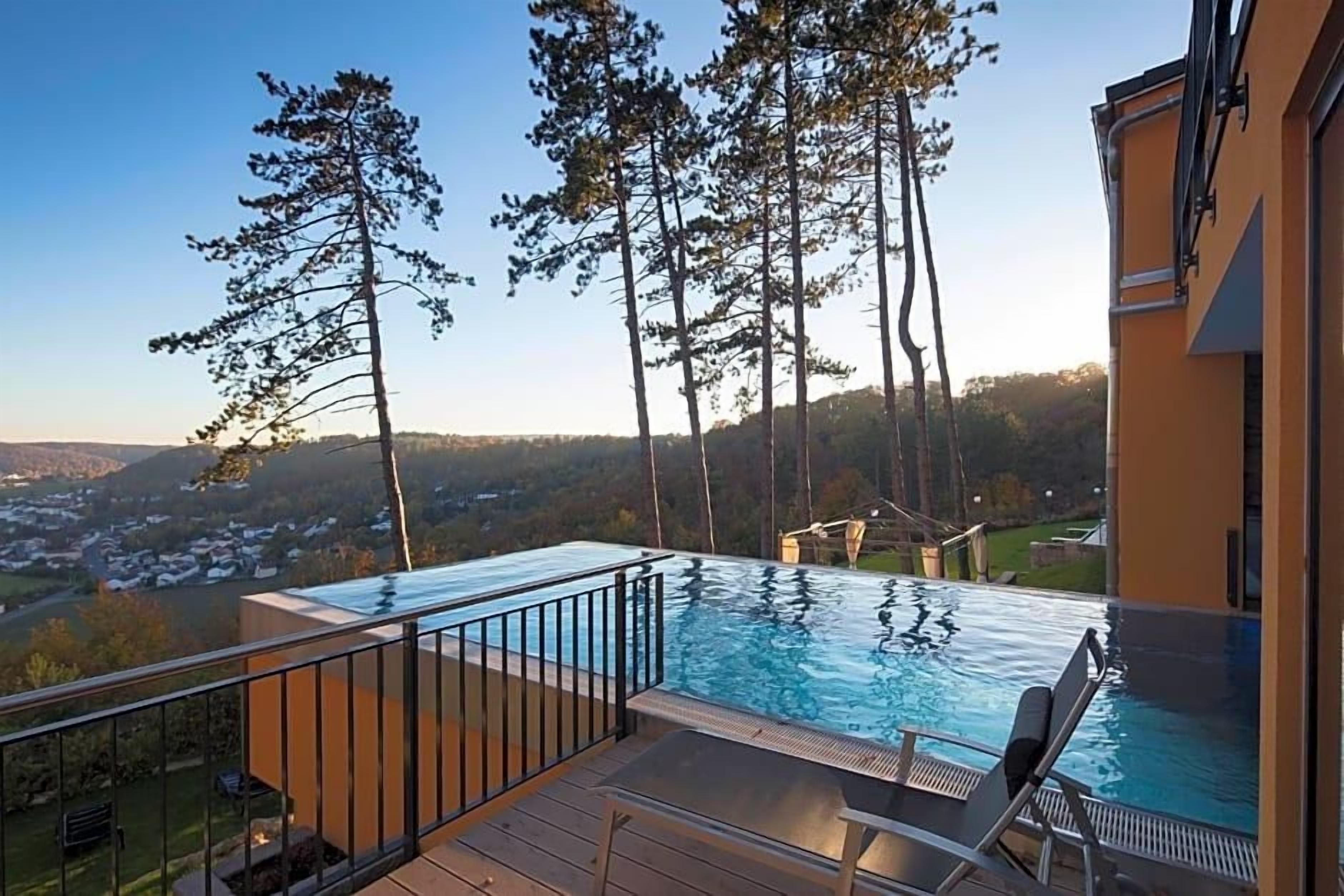 A swimming pool with a view of a town and hills.